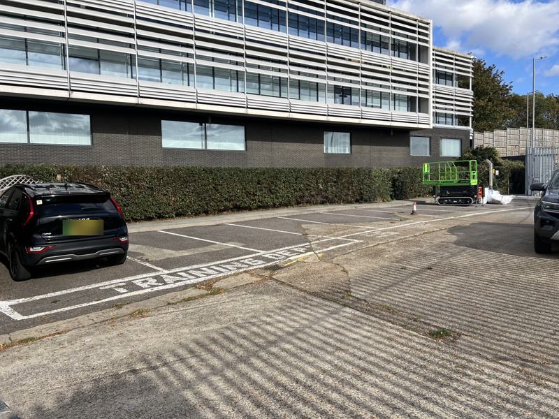 Long hedge neatly cut and cleared up alongside an office car park